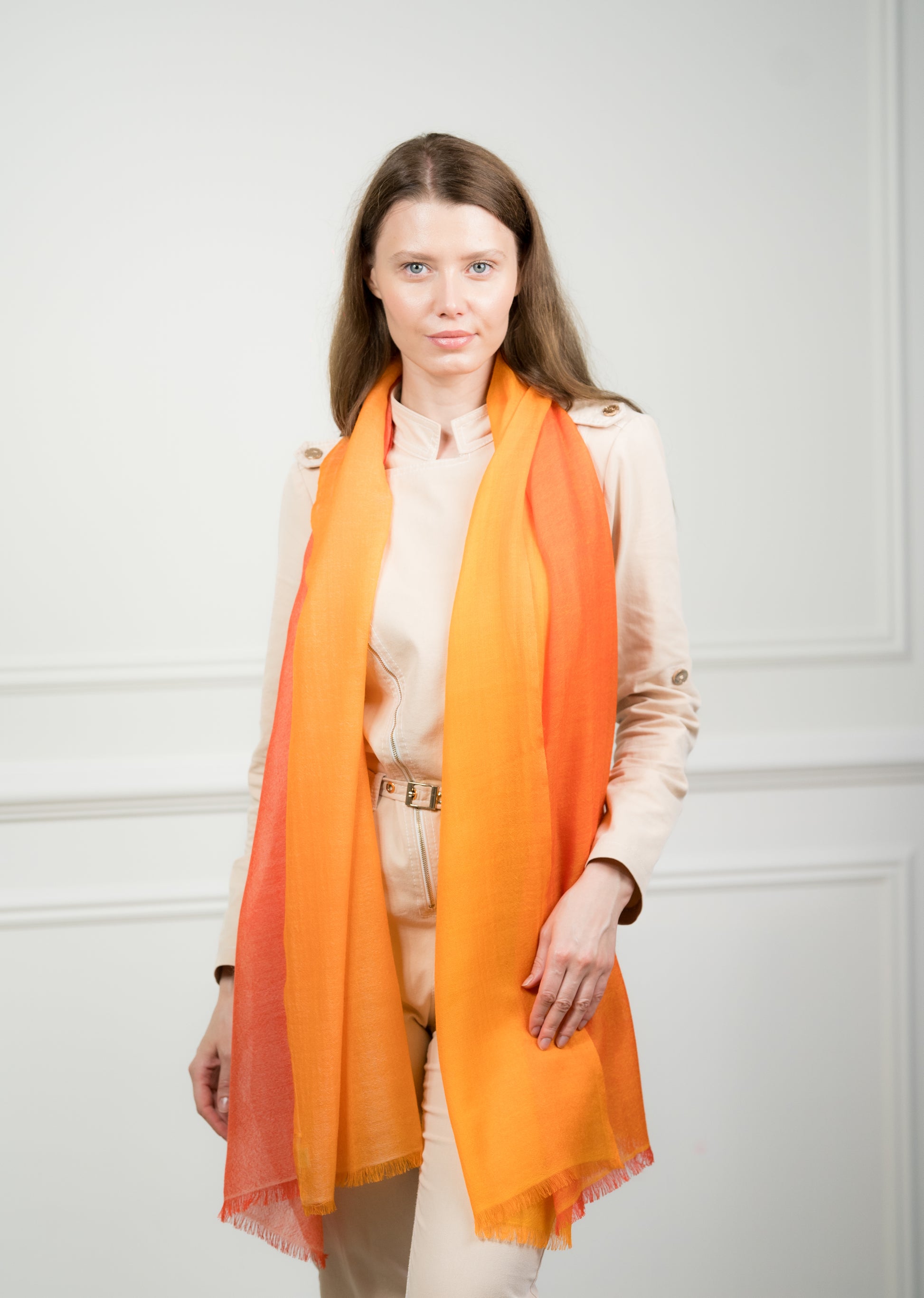 Model draping the 4 Color Block Tangerine Scarf over shoulders, showcasing the interplay of tangerine orange, gray, beige, and white color blocks.