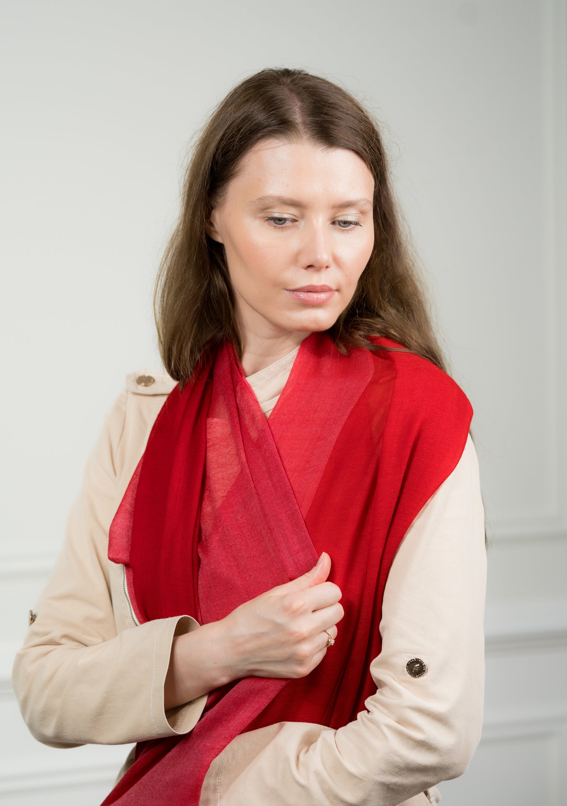 Pure wool 4 Color Block Scarlet Scarf styled in a loose knot on a model, displaying the vibrant scarlet red and beige sections with fringed edges.