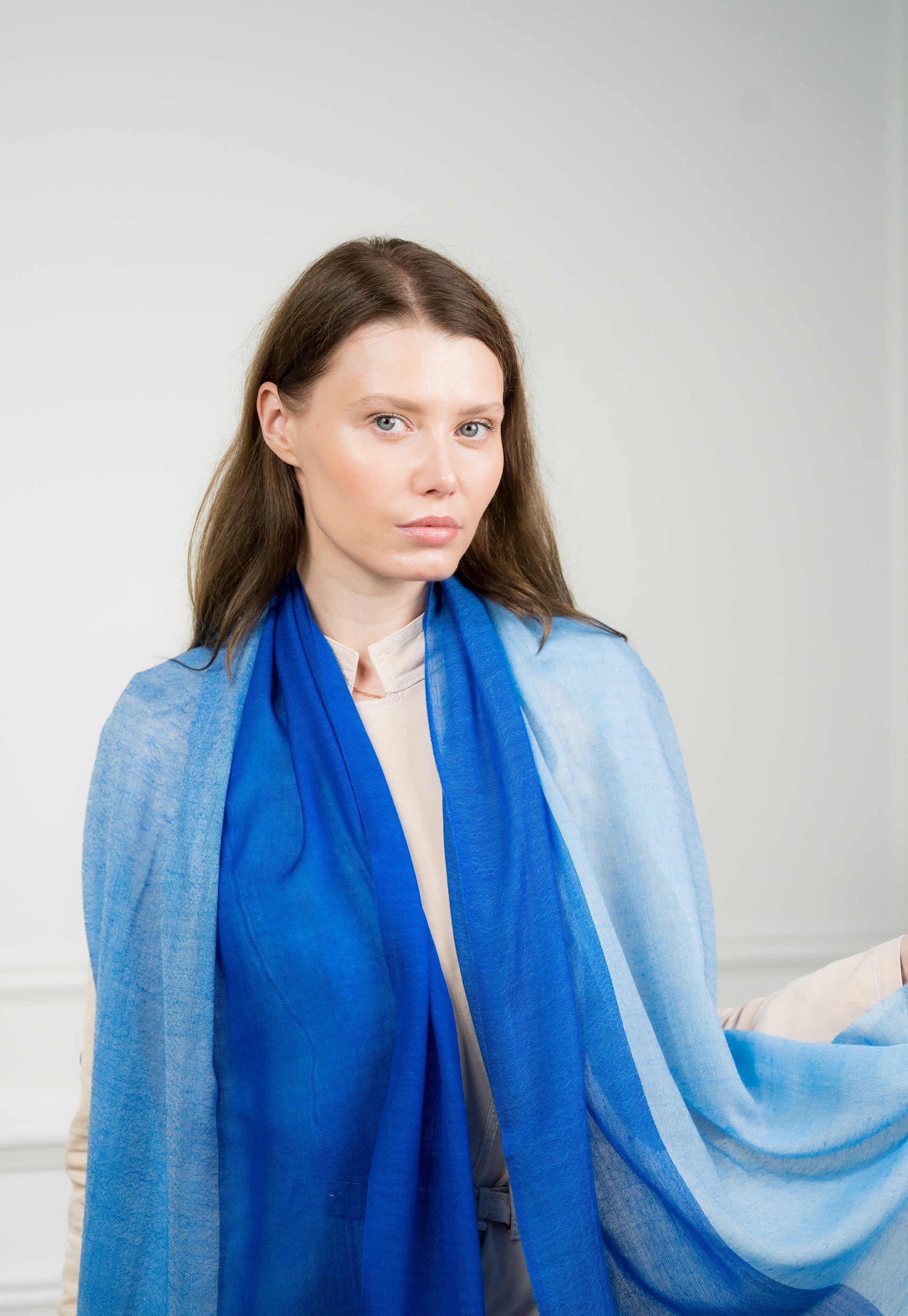Model elegantly draping the 4 Color Block Cobalt Scarf over shoulders, emphasizing the interplay of cobalt blue, gray, beige, and white color blocks.