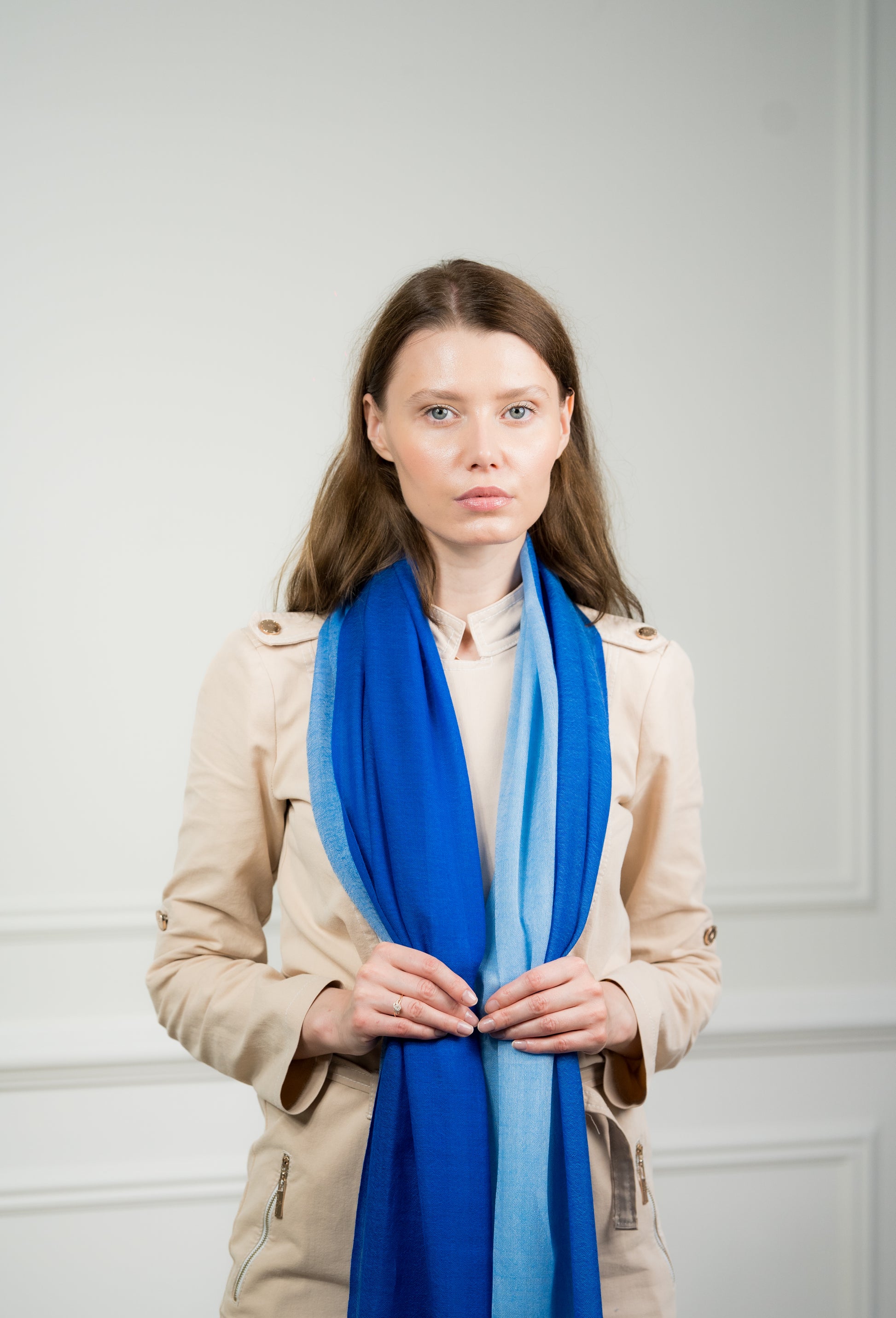 Pure wool 4 Color Block Cobalt Scarf styled in a loose knot on a model, displaying the vibrant cobalt blue and beige sections with fringed edges.