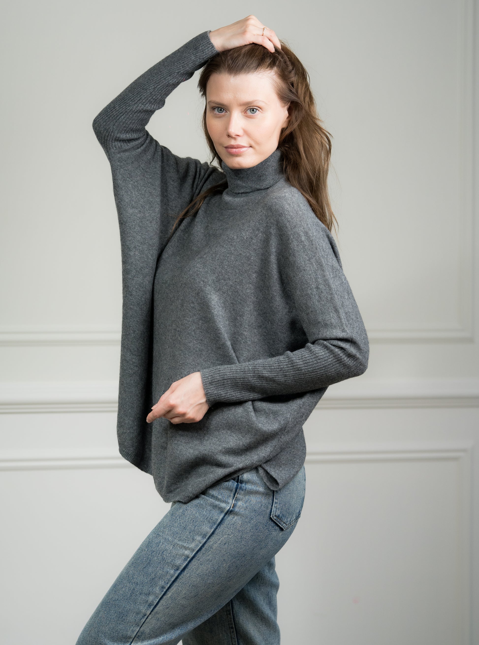 Model pairing the Charcoal Boxy Sweater with jeans, illustrating its versatility for both casual and formal occasions.