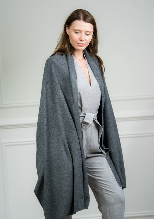 Model wearing Caprus Cashmere's pure cashmere Charcoal Travel Wrap, showcasing its generous size and versatile charcoal gray hue.