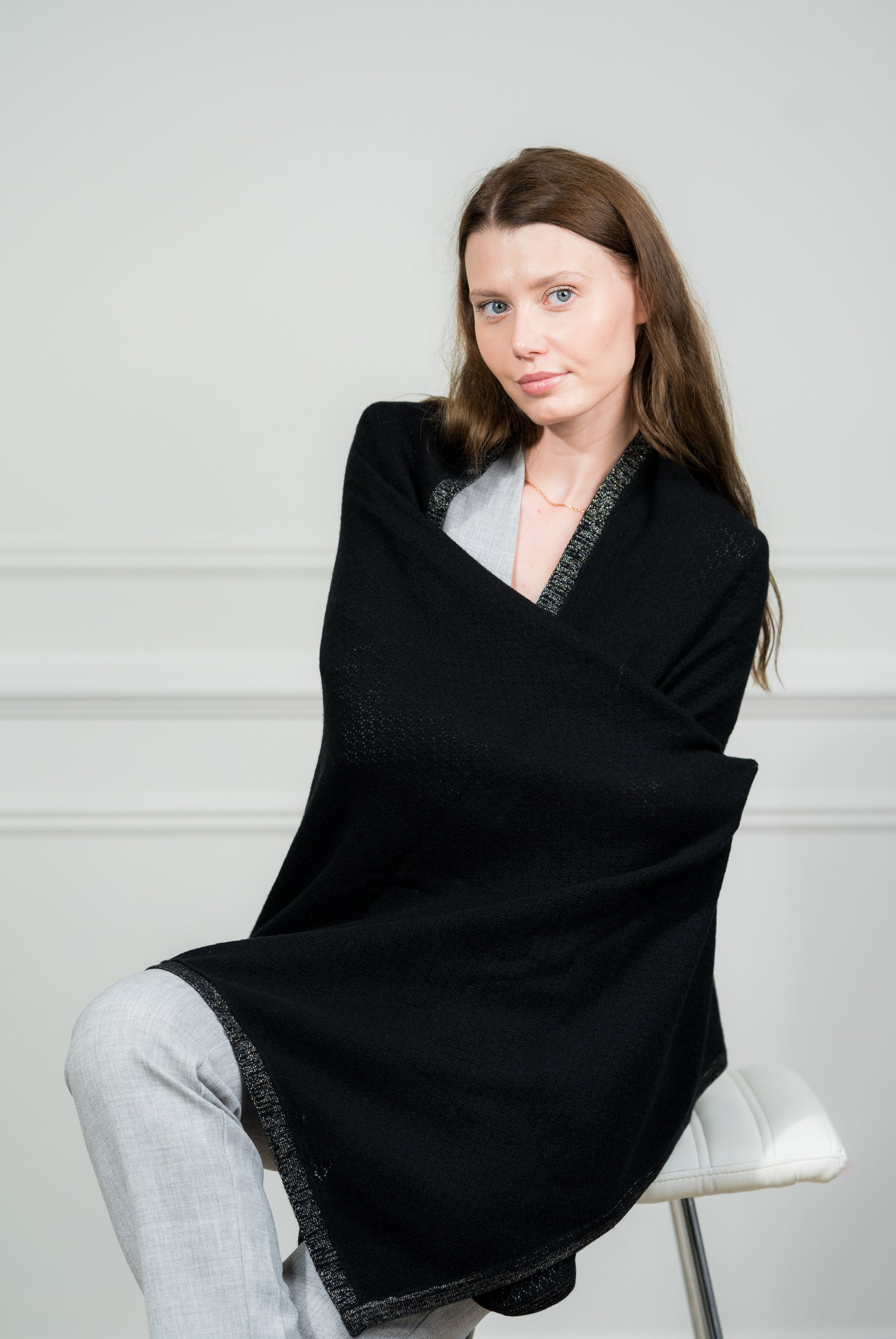Close-up of the Black Pointelle Wrap on a model, highlighting the intricate pointelle knit pattern and soft, luxurious cashmere texture.