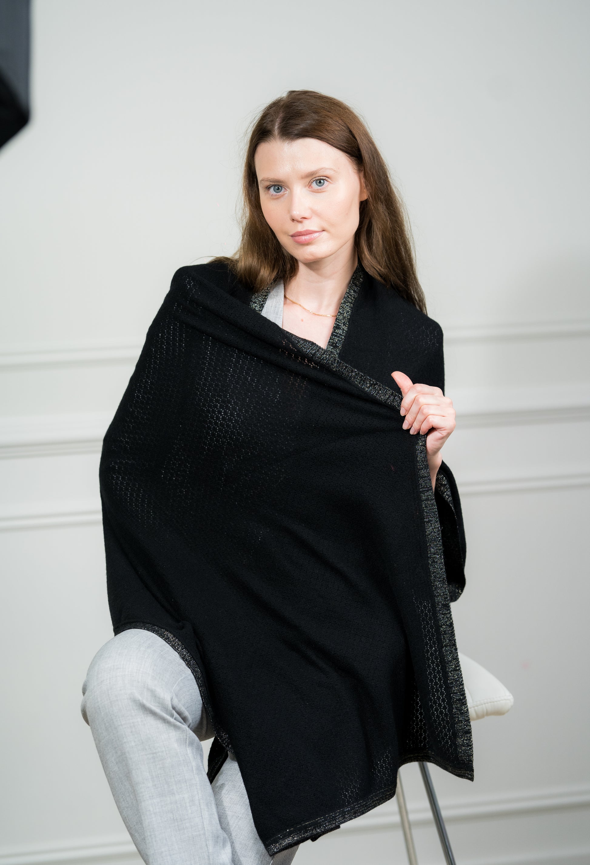 Model draping the Black Pointelle Wrap over shoulders, showcasing its versatile design as a women scarf and travel wrap for casual or formal wear.