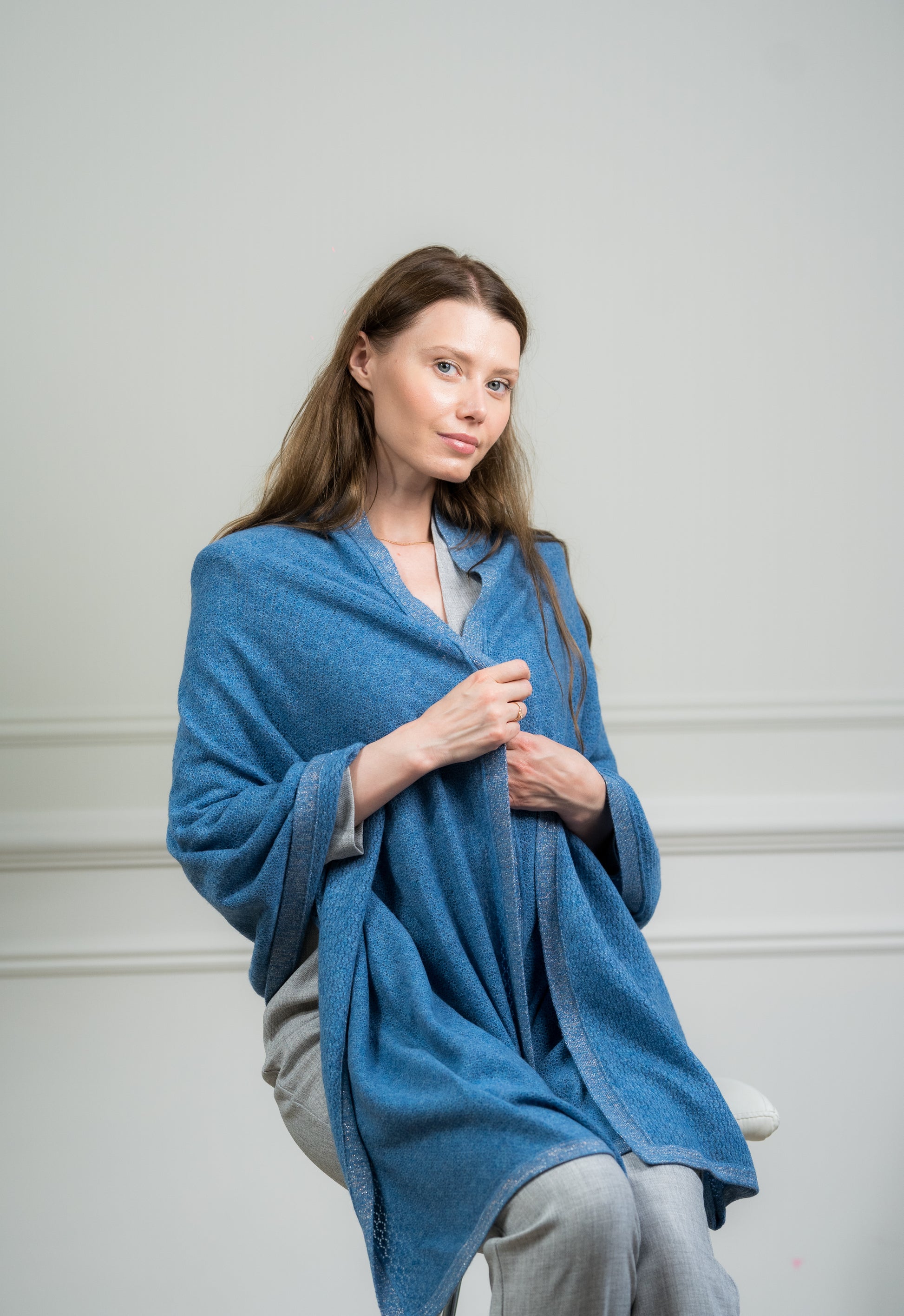 Model draping the Sky Pointelle Wrap over shoulders, illustrating its versatility as a women's scarf and travel wrap.