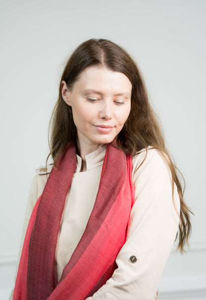 Side profile of a model wearing the Herringbone Ruby Four Color Block Scarf, illustrating its elegant design and vibrant ruby red color block.
