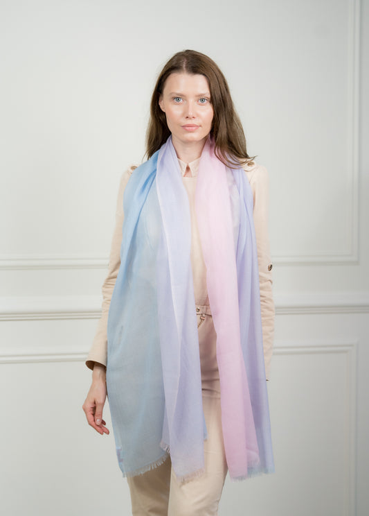 Pure wool scarf with four color blocks—azure, teal, beige, and gray—featuring fringed edges, styled over a neutral outfit.
