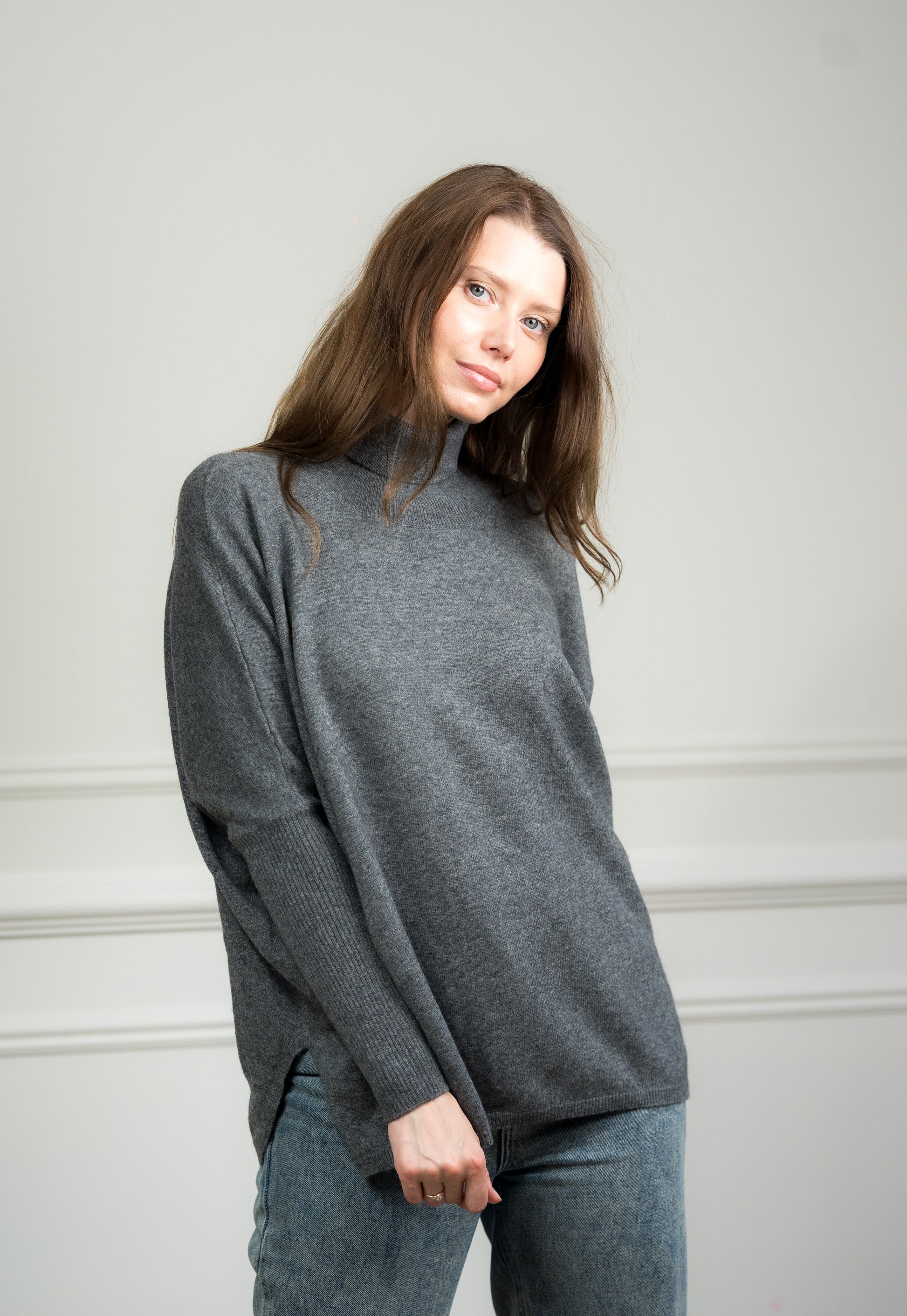 Side view of the Charcoal Boxy Sweater worn by a model, emphasizing its loose silhouette and dropped shoulder design.