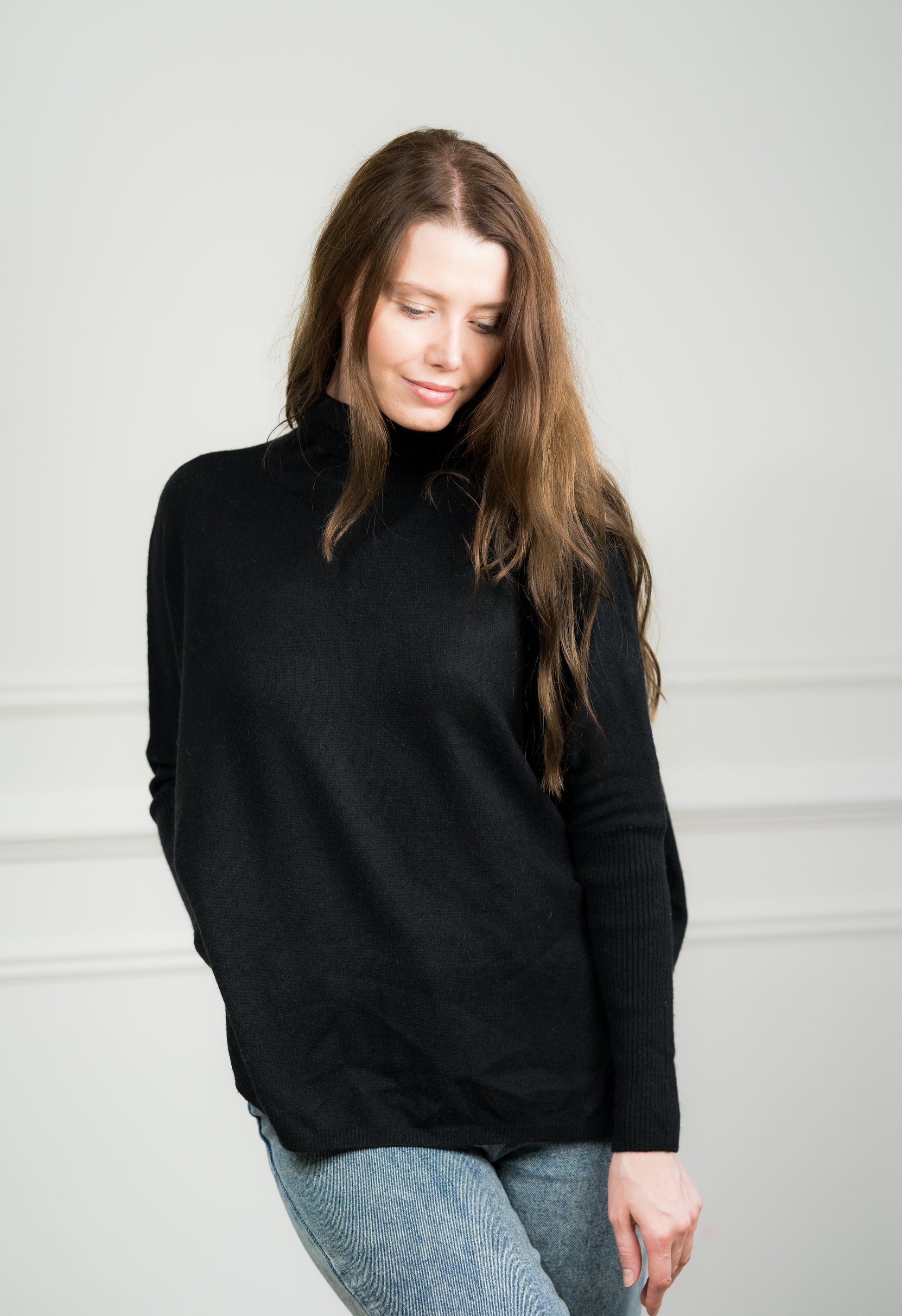 Model wearing Caprus Cashmere's pure cashmere Black Boxy Sweater, showcasing its relaxed fit and classic crew neckline.