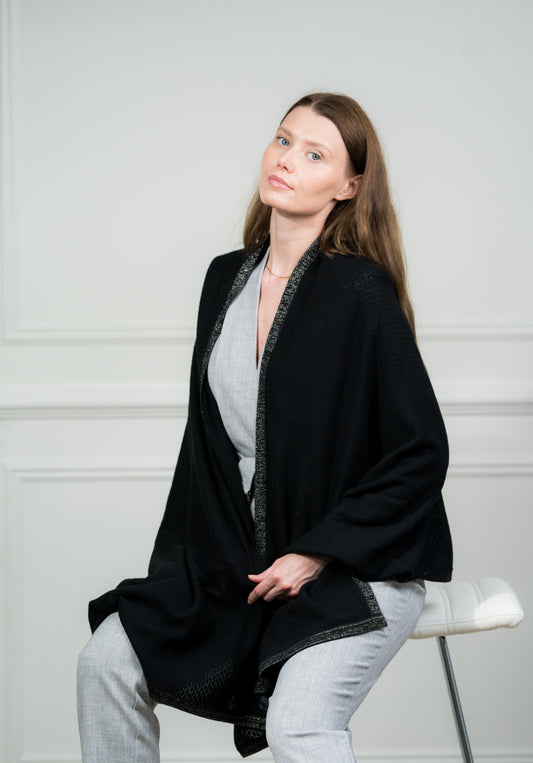 Model wearing Caprus Cashmere's Black Pointelle Wrap, a pure cashmere women scarf, ideal as a lightweight travel wrap for any occasion.