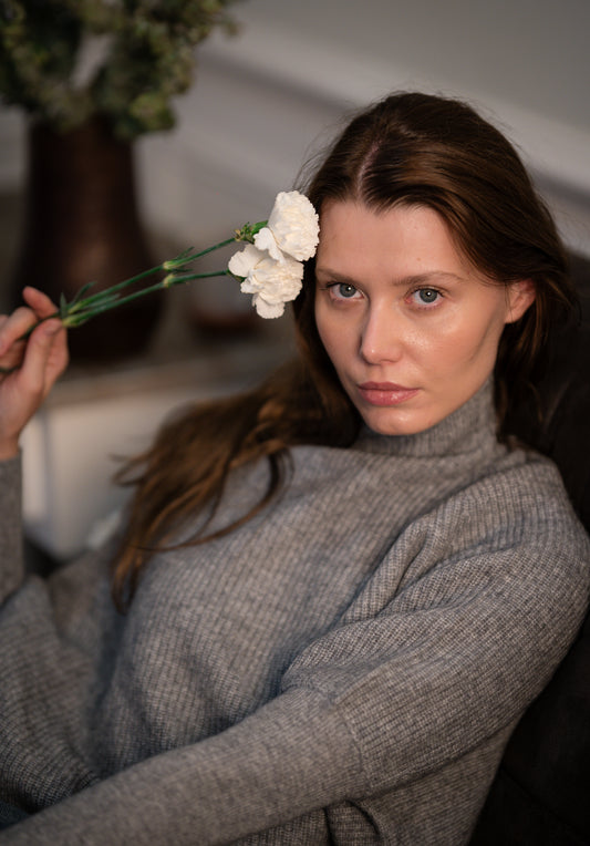 Model wearing Caprus Cashmere's pure cashmere Ribbed High Neck Sweater in grey, showcasing its luxurious texture and stylish design.