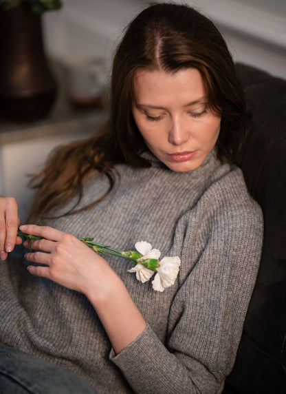 Side view of the Ribbed High Neck Sweater worn by a model, emphasizing its relaxed fit and high neckline.